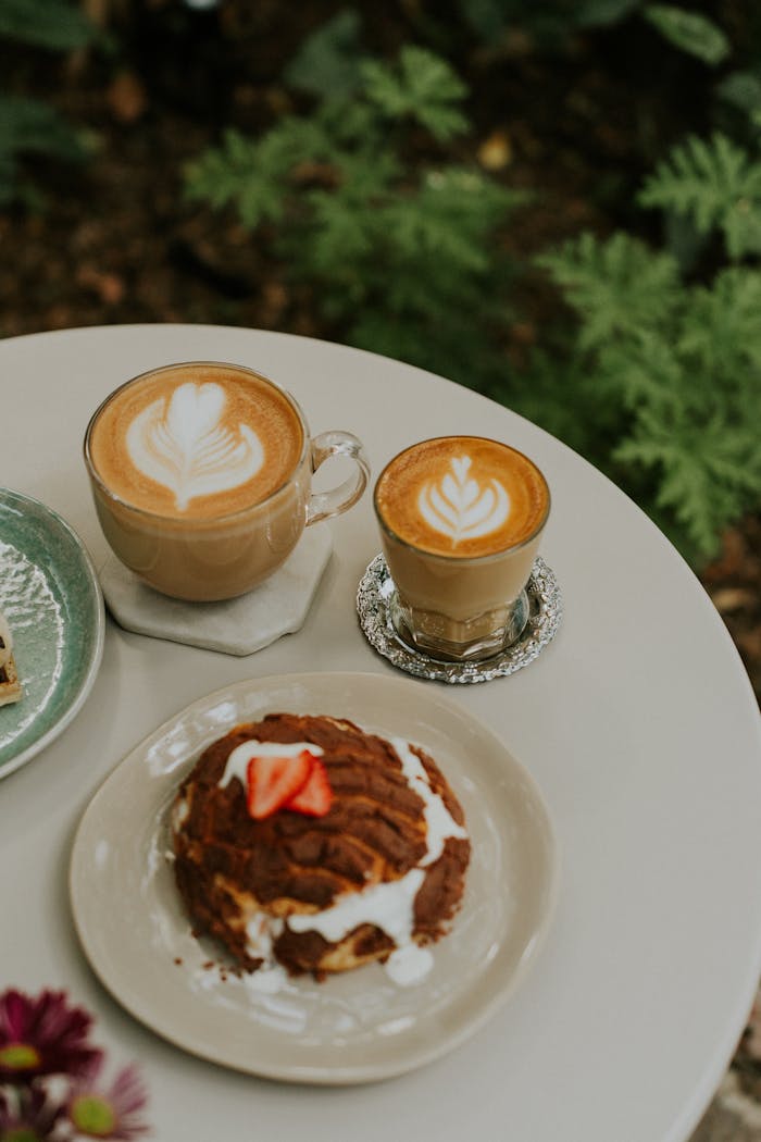 Coffee and pastries on a table with a plant